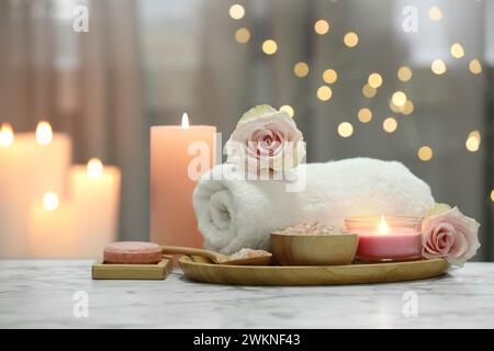 Schöne Komposition mit verschiedenen Spa-Produkten und Rosenblüten auf weißem Marmortisch Stockfoto