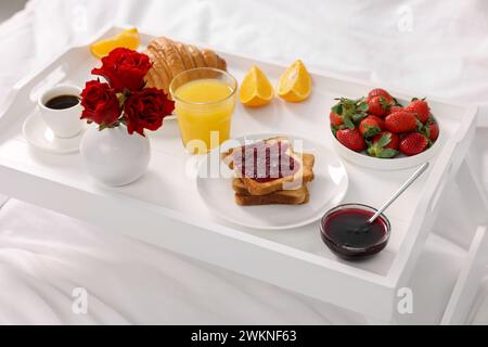 Tablett mit leckerem Frühstück auf dem Bett, Nahaufnahme Stockfoto