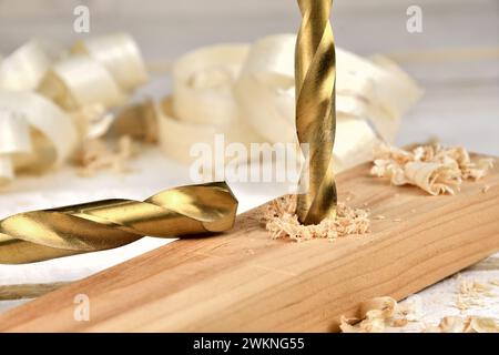 Golden Twist Bohrer schneidet durch Holzstück Stockfoto