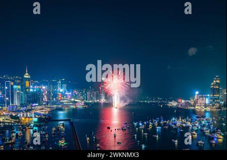 Das Feuerwerk brach hell über der Skyline der Stadt über dem Nachthimmel und spiegelte sich im ruhigen Wasser darunter Stockfoto