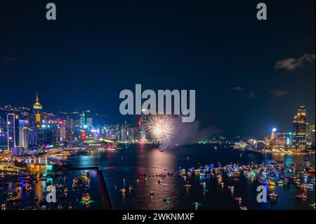 Das Feuerwerk brach hell über der Skyline der Stadt über dem Nachthimmel und spiegelte sich im ruhigen Wasser darunter Stockfoto