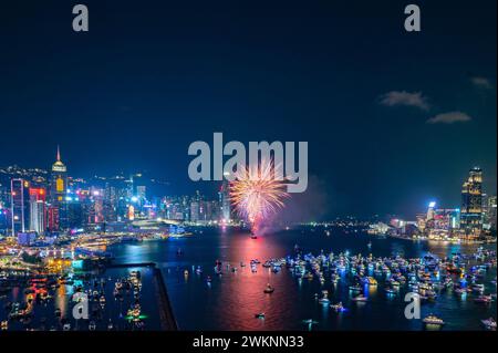 Das Feuerwerk brach hell über der Skyline der Stadt über dem Nachthimmel und spiegelte sich im ruhigen Wasser darunter Stockfoto