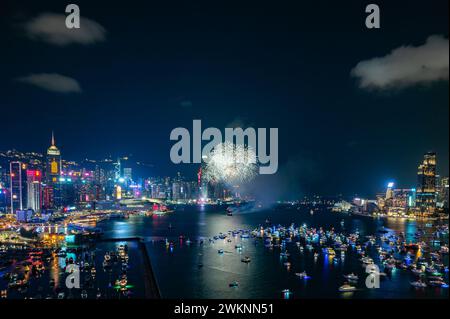 Das Feuerwerk brach hell über der Skyline der Stadt über dem Nachthimmel und spiegelte sich im ruhigen Wasser darunter Stockfoto