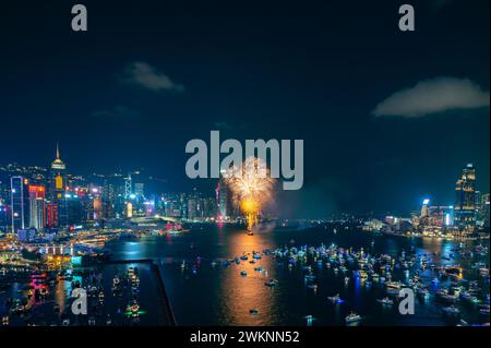 Das Feuerwerk brach hell über der Skyline der Stadt über dem Nachthimmel und spiegelte sich im ruhigen Wasser darunter Stockfoto