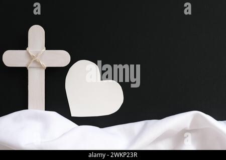 Weißes Holzkreuz und Stoff als Symbol des Himmels. Begräbnis- und Beerdigungshintergrund und Sympathiekarte. Stockfoto