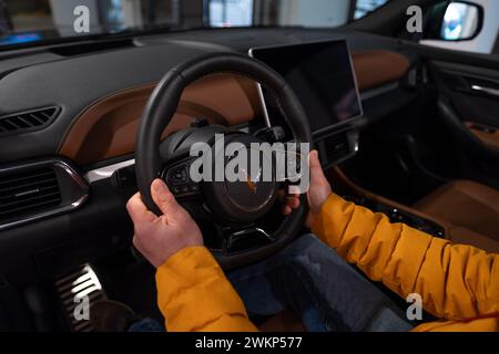 Männliche Hände am Lenkrad, Innenraum, Cockpit der elektrischen Frequenzweiche Vinfast vf 8, fortschrittliche Technologien in der vietnamesischen Automobilindustrie, Probefahrt Stockfoto