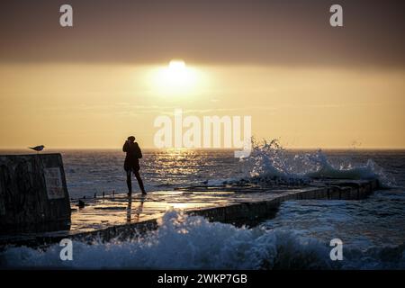 Odessa, Ukraine. Februar 2024. Eine Frau fotografiert am frühen Morgen den Sonnenaufgang über dem Schwarzen Meer am Ufer der Hafenstadt Odessa. Am 24. Februar 2024 jährt sich der Beginn des russischen Aggressionskrieges gegen die Ukraine zum zweiten Mal. Quelle: Kay Nietfeld/dpa/Alamy Live News Stockfoto