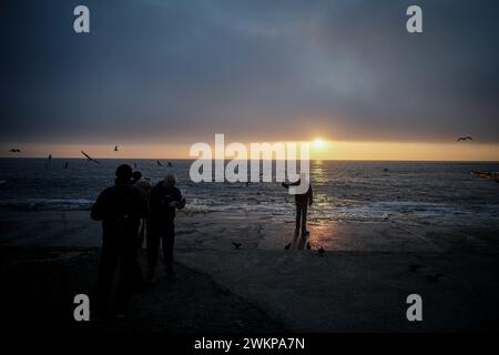 Odessa, Ukraine. Februar 2024. Ein Passant macht am frühen Morgen ein Foto vom Sonnenaufgang über dem Schwarzen Meer am Ufer der Hafenstadt Odessa. Am 24. Februar 2024 jährt sich der Beginn des russischen Aggressionskrieges gegen die Ukraine zum zweiten Mal. Quelle: Kay Nietfeld/dpa/Alamy Live News Stockfoto