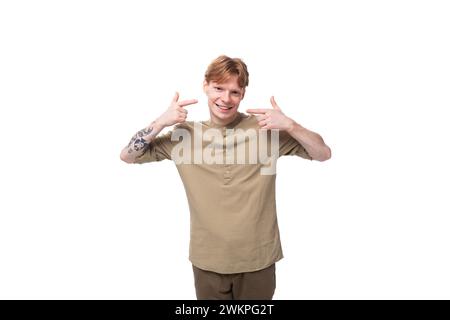Junger rothaariger Mann in einem beigen Hemd auf weißem Hintergrund Stockfoto