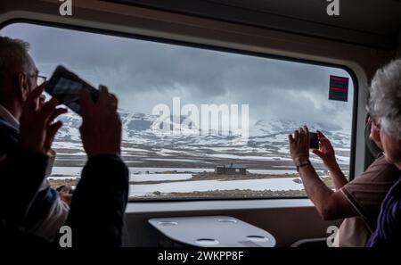 Bergen, Norwegen, 22. Juni 2023: Passagiere machen Fotos mit ihrem Smartphone vor dem Fenster eines Personenwagens des Zuges von Oslo nach Bergen of Stockfoto