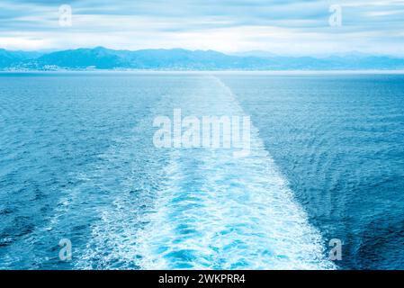 Gerade Schiffsspur im Meer gegen ferne Küste Stockfoto