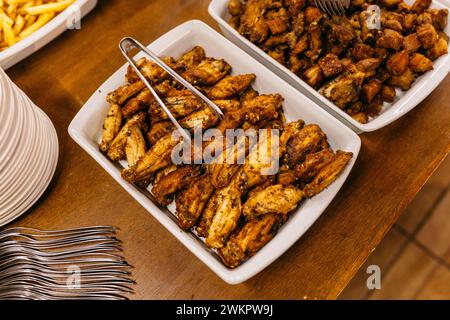 Ein hölzerner Tisch mit weißen Tellern und einer Auswahl an leckeren Speisen Stockfoto