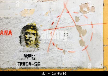 TOMAR, PORTUGAL - 28. APRIL 2015: Graffiti von Che Guevara auf der alten Hauswand, Text in Portugiesisch „zum Verkauf, zum Austausch“ und Anarchie-Symbol. Stockfoto