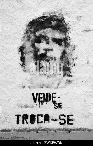 Tomar, Portugal - 28. April 2015: Che Guevara Graffiti an der alten Hauswand und Text auf Portugiesisch „zum Verkauf, zum Austausch“. Stockfoto