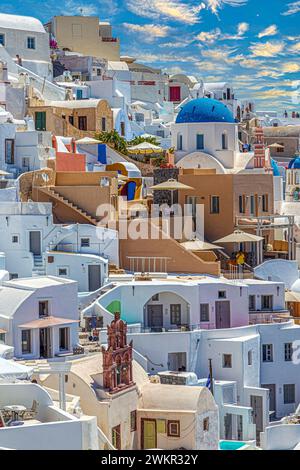 OIA, SANTORINI, GRIECHENLAND - 21. JUNI 2021: Typische weiß-blaue Architektur mit Kuppeln, Kirchen, Hotels und Restaurants des Dorfes Oia auf Santorin i Stockfoto