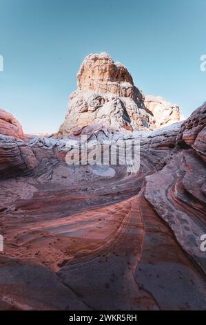 USA, ARIZONA, WHITE POCKET: Die White Pocket ist ein abgelegenes, bekanntermaßen schwer zugängliches Sandsteinstück, das sich in der Wüste des Vermillion Cliffs National Monument nahe der Grenze zu Arizona/Utah versteckt. Das gesamte Gebiet ist mit einer grauen Felsschicht bedeckt, manchmal nur wenige Zentimeter dick, über dem roten Sandstein, wo die Formationen heulen und tropfen, die die gesamte Landschaft so aussehen lässt, als wäre sie mit Puderzucker bedeckt. An manchen Stellen sind die Steinschichten völlig verdreht, wie ein riesiger Marmorkuchen. Stockfoto