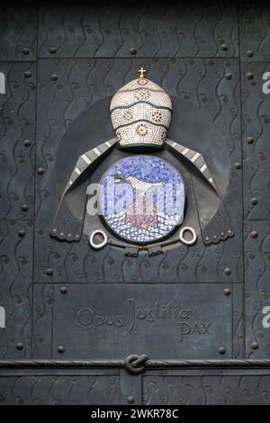 Papsttür am südlichen Querschiff des Doms, Köln, Deutschland. Bronzeguss mit Mosaikeinlagen von Ewald Mataré, Emblem von Papst Pius XII Stockfoto