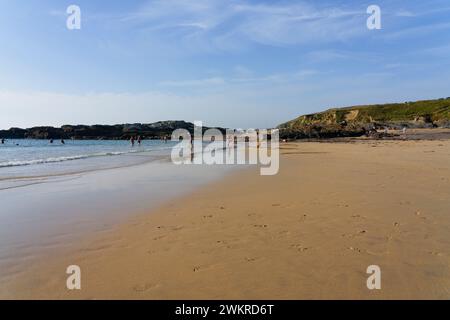 Godrevy - England, 7. September 2023: An einem Septembernachmittag schwimmen oder paddeln kleine Menschen im Meer am Godrevy Beach, Cornwall Stockfoto