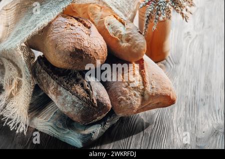 Auswahl an verschiedenen köstlichen frisch gebackenen Broten auf weißem Holzhintergrund. Ciabatta, grissini, Gebäck, Baguette verschiedener Sorten. Homema Stockfoto