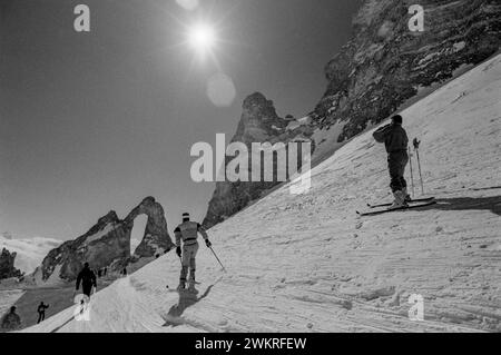 Tigne, Skifahren in der Region Rhône-Alpes im Südosten Frankreichs 1988 ein weiteres auffälliges Wahrzeichen von Tignes ist die natürlich vorkommende Felsformation The Eye of the Needle, die sich auf der Spitze des Aiguille Percee befindet. Tignes ist eine Gemeinde im Tarentaise-Tal im Département Savoie in der Region Rhône-Alpes im Südosten Frankreichs, bekannt für das höchste Skigebiet[3] und die längste Skisaison in Europa. Es liegt in der Region Savoie mit guter Verkehrsanbindung in und aus Lyon, Genf und Chambéry. Es ist am besten als schneesicheres Skigebiet bekannt. Zusammen mit dem benachbarten Val Stockfoto