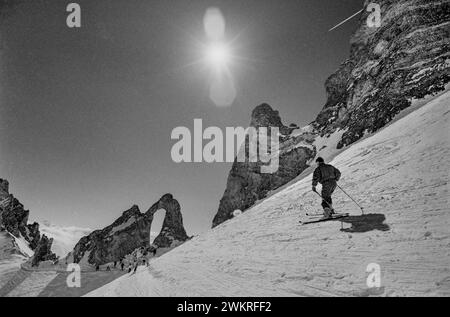 Tigne, Skifahren in der Region Rhône-Alpes im Südosten Frankreichs 1988 ein weiteres auffälliges Wahrzeichen von Tignes ist die natürlich vorkommende Felsformation The Eye of the Needle, die sich auf der Spitze des Aiguille Percee befindet. Tignes ist eine Gemeinde im Tarentaise-Tal im Département Savoie in der Region Rhône-Alpes im Südosten Frankreichs, bekannt für das höchste Skigebiet[3] und die längste Skisaison in Europa. Es liegt in der Region Savoie mit guter Verkehrsanbindung in und aus Lyon, Genf und Chambéry. Es ist am besten als schneesicheres Skigebiet bekannt. Zusammen mit dem benachbarten Val Stockfoto