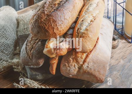 Auswahl an verschiedenen köstlichen frisch gebackenen Broten auf weißem Holzhintergrund. Ciabatta, grissini, Gebäck, Baguette verschiedener Sorten. Homema Stockfoto