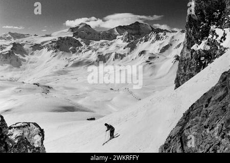 Tigne, Skifahren in der Region Rhône-Alpes im Südosten Frankreichs 1988 ein weiteres auffälliges Wahrzeichen von Tignes ist die natürlich vorkommende Felsformation The Eye of the Needle, die sich auf der Spitze des Aiguille Percee befindet. Tignes ist eine Gemeinde im Tarentaise-Tal im Département Savoie in der Region Rhône-Alpes im Südosten Frankreichs, bekannt für das höchste Skigebiet[3] und die längste Skisaison in Europa. Es liegt in der Region Savoie mit guter Verkehrsanbindung in und aus Lyon, Genf und Chambéry. Es ist am besten als schneesicheres Skigebiet bekannt. Zusammen mit dem benachbarten Val Stockfoto