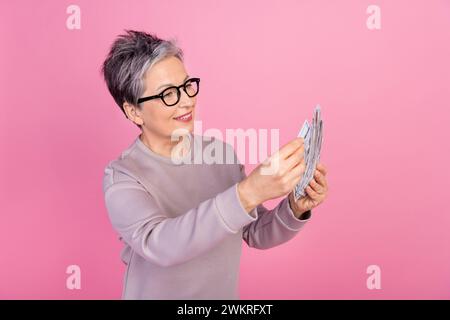 Foto der erfolgreichen reichen Frau tragen trendige Kleidung zählt Einsparungen Cash Investment Nutzen isoliert auf rosafarbenem Hintergrund Stockfoto