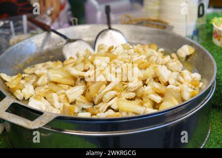 Frischer Tintenfisch, der in einer großen Pfanne auf einem geschäftigen Street Food Market perfekt gebraten wird, ein beliebter Snack bei Einheimischen und Touristen gleichermaßen Stockfoto