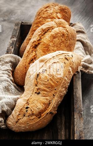 Köstliches frisch gebackenes Sauerteigbrot ohne Hefe auf hölzernem Hintergrund. Hausgemachtes gesundes Brot in einem Korb, Nahaufnahme. Stockfoto