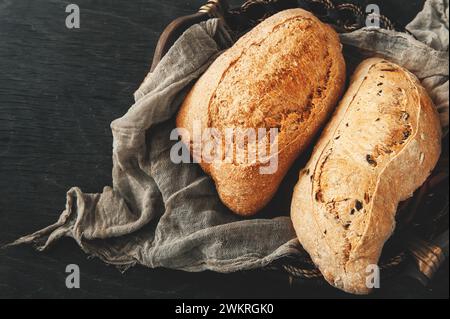 Köstliches frisch gebackenes Sauerteigbrot ohne Hefe auf hölzernem Hintergrund. Hausgemachtes gesundes Brot in einem Korb, Nahaufnahme. Stockfoto