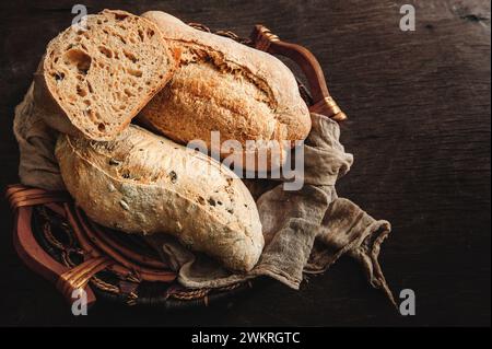 Köstliches frisch gebackenes Sauerteigbrot ohne Hefe auf hölzernem Hintergrund. Hausgemachtes gesundes Brot in einem Korb, Nahaufnahme. Stockfoto