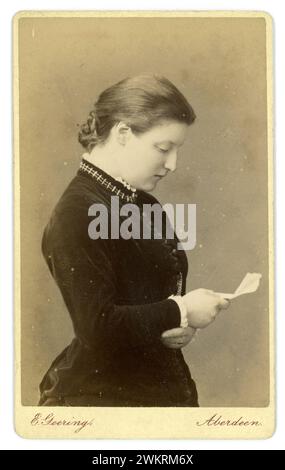 Originelle, charmante und klare viktorianische Carte de Visite (Visitenkarte oder CDV) - ein Profil einer jungen viktorianischen Frau, viktorianische Dame, genannt Jessie, posiert mit einem offenen Buch, aus dem Studio von E. Geering, 10 Union Place, spät von GW Wilson & Co Aberdeen, Schottland von den frühen 1880er Jahren bis etwa 1889, sagt Mode 1881 Stockfoto