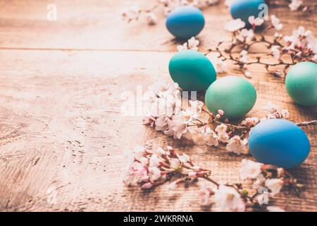 Osterhintergrund mit bunten Eiern im Nest auf hölzernem Hintergrund Stockfoto