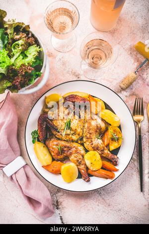 Gebratenes Huhn mit Kartoffeln, Gemüse und Salat auf einem Tisch Stockfoto