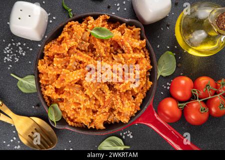 Mafaldine Nudeln mit Tomatensauce, italienischem Bolognese, Tomatenmarinara, veganen Pilzen oder Auberginen Sauce Nudeln auf schwarzem Betonhintergrund, mit ingre Stockfoto