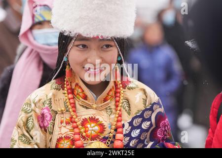 (240222) -- XIAHE, 22. Februar 2024 (Xinhua) -- Ein tibetisches Mädchen posiert für Fotos nach der jährlichen Zeremonie der 'Sonne des Buddha' des Klosters Labrang im County Xiahe, nordwestchinesische Provinz Gansu, 22. Februar 2024. Mehr als 40.000 Gläubige und Touristen aus dem in- und Ausland nahmen an einer großen tibetisch-buddhistischen Veranstaltung Teil, bekannt als die Zeremonie der „Sonne des Buddha“, die am Donnerstag im Kloster Labrang in der nordwestchinesischen Provinz Gansu stattfand. Die jährliche Veranstaltung ist eine der wichtigsten Zeremonien im 1709 erbauten Kloster Labrang, einem der sechs großen Tempel der Gelug-Schule tibetischer Buddhi Stockfoto