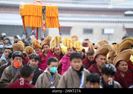 (240222) -- XIAHE, 22. Februar 2024 (Xinhua) -- Mönche tragen ein riesiges Thangka-Gemälde mit dem Bild des Buddha während der jährlichen Zeremonie der 'Sonnensonne des Buddha' des Labrang-Klosters in Xiahe County, nordwestchinesische Provinz Gansu, 22. Februar 2024. Mehr als 40.000 Gläubige und Touristen aus dem in- und Ausland nahmen an einer großen tibetisch-buddhistischen Veranstaltung Teil, bekannt als die Zeremonie der „Sonne des Buddha“, die am Donnerstag im Kloster Labrang in der nordwestchinesischen Provinz Gansu stattfand. Die jährliche Veranstaltung ist eine der wichtigsten Zeremonien im Kloster Labrang, erbaut 1709, einem der sechs großen Tempel Stockfoto