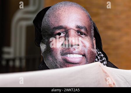 London, Großbritannien. Februar 2024. Ein pro-palästinensischer Aktivist aus London für ein freies Palästina, der eine Maske trägt, die ein Bild von David Lammy, dem Schattenstaatssekretär für auswärtige Angelegenheiten, Commonwealth und Entwicklung, zeigt, Proteste vor dem Sitz der Labour Party, um zu fordern, dass die Labour-Abgeordneten heute Abend im Parlament für den SNP-Antrag stimmen, der einen sofortigen und dauerhaften Waffenstillstand in Gaza fordert. Quelle: Mark Kerrison/Alamy Live News Stockfoto