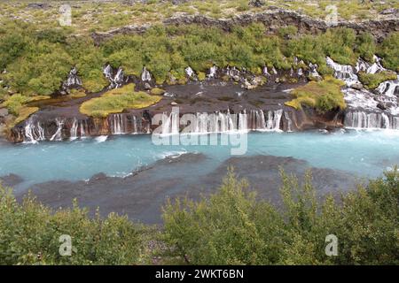 Hraunfossar, eine Reihe von Wasserfällen, die von Rinneiern gebildet werden, die über eine Distanz von etwa 900 Metern aus dem Hallmundarhraun, einem Lavafeld, strömen Stockfoto