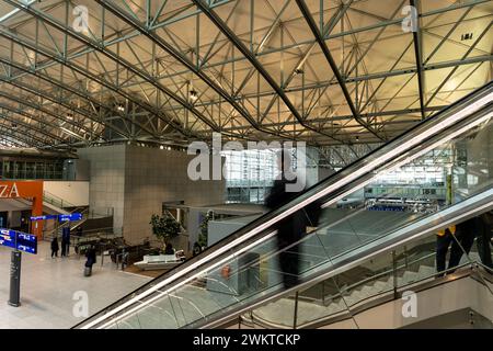 Flughafen Frankfurt - 12. Februar 2024: Silhouette eines Passagiers auf einer Rolltreppe in der Halle von Terminal 2 der Frankfurter internationalen Luftfahrt Stockfoto