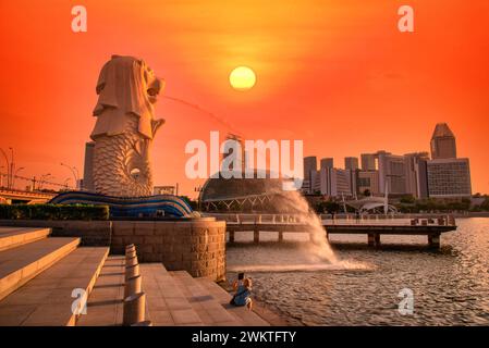 SINGAPUR-9. JULI 2016: Brunnen der Merlion-Statue im Merlion Park und Skyline der Stadt Singapur bei Sonnenaufgang am 9. Juli 2016. Der Merlion-Brunnen ist einer der Stockfoto