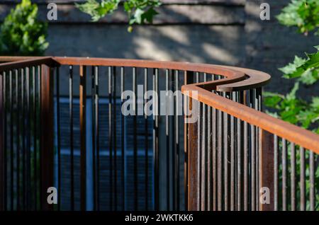 Geländer aus Corten-Stahl, mit oxidierten, rostfesten Eisenelementen. Attika der erhöhten Struktur. Architektur im Dialog zwischen Vergangenheit und Moderne. Stockfoto