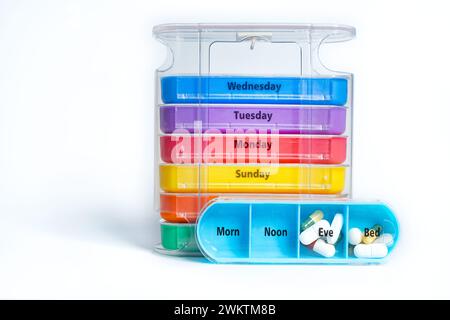 Ein stapelbarer wöchentlicher Pillen-Organisator, der viermal täglich pro Tag verwendet werden kann. Die Tablettenschachtel verfügt über ein Tablett für jeden Wochentag mit vier gekennzeichneten separaten Fächern. Stockfoto