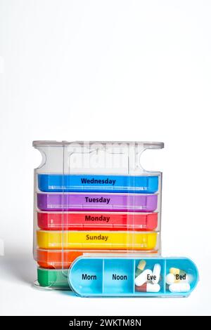 Ein stapelbarer wöchentlicher Pillen-Organisator, der viermal täglich pro Tag verwendet werden kann. Die Tablettenschachtel verfügt über ein Tablett für jeden Wochentag mit vier gekennzeichneten separaten Fächern. Stockfoto
