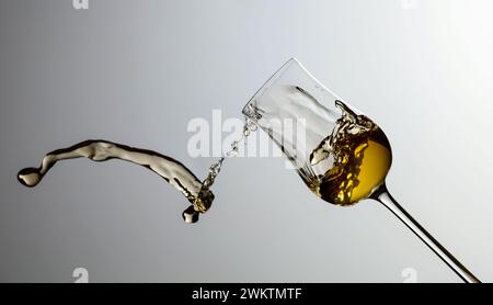 Das Getränk wird aus dem Glas verschüttet. Konzept des Themas Premium-Alkohol. Speicherplatz kopieren. Stockfoto