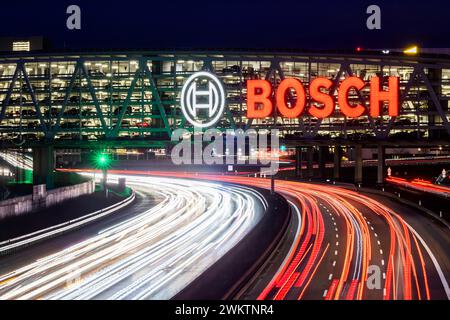 Autobahn A8 am Flughafen Stuttgart mit Bosch-Parkhaus. Die 440 Meter lange Konstruktion bietet 4200 Fahrzeuge Platz. Bosch hat die Namensrechte, der stilisierte Zündanker misst 12 Meter im Durchmesser. Damit ist es eine der größten Leuchtreklamen der Welt. // 04.05.2024: Stuttgart, Baden-Württemberg, Deutschland. *** Autobahn A8 am Flughafen Stuttgart mit Bosch-Parkhaus der 440 Meter lange Baukörper bietet Platz für 4.200 Fahrzeuge Bosch hat die Namensrechte, der stilisierte Zündanker misst 12 Meter Durchmesser und ist damit eines der größten Leuchtschilder der Welt Stockfoto