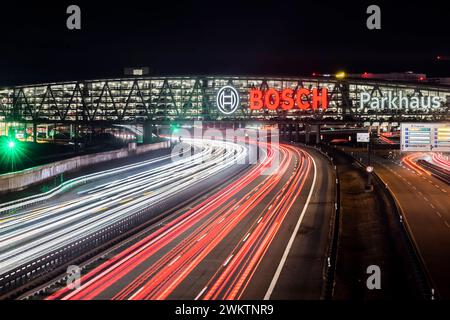 Autobahn A8 am Flughafen Stuttgart mit Bosch-Parkhaus. Die 440 Meter lange Konstruktion bietet 4200 Fahrzeuge Platz. Bosch hat die Namensrechte, der stilisierte Zündanker misst 12 Meter im Durchmesser. Damit ist es eine der größten Leuchtreklamen der Welt. // 04.05.2024: Stuttgart, Baden-Württemberg, Deutschland. *** Autobahn A8 am Flughafen Stuttgart mit Bosch-Parkhaus der 440 Meter lange Baukörper bietet Platz für 4.200 Fahrzeuge Bosch hat die Namensrechte, der stilisierte Zündanker misst 12 Meter Durchmesser und ist damit eines der größten Leuchtschilder der Welt Stockfoto