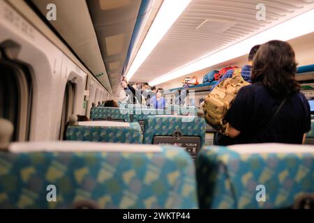 Passagiere an Bord eines Hochgeschwindigkeitszugwagens THSR 700T, während sie durch den Gang gehen und nach ihrem Sitzplatz suchen; Taiwan High Speed Rail Corporation; Taipeh Stockfoto