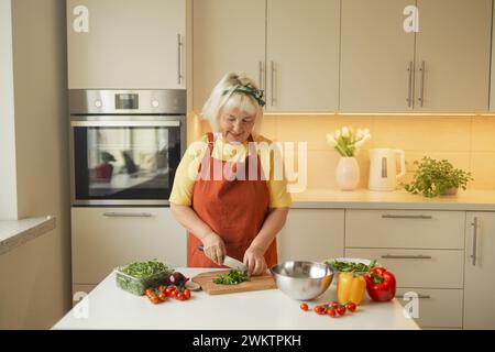 Nahaufnahme zugeschnittenes Bild eines weiblichen Schneidebretts, das Gemüse in der Küche schneidet und Mahlzeiten zuhause zubereitet. Vegetarische gesunde Ernährung Stockfoto